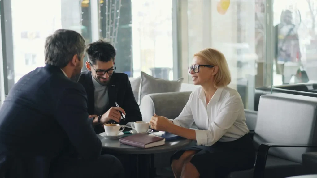 Two businessmen consulting with a Realtor realize that their counterparts who ask them “why hire a Real Estate Agent” miss out on the preparation and positioning that a Realtor has to offer.