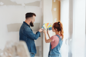 A young couple excitedly discusses which colors to use in their home renovation project.
