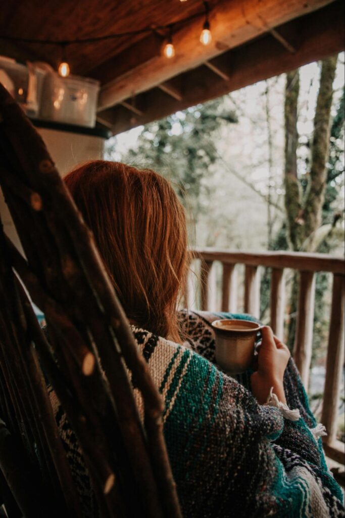 Woman enjoying a quiet, contented, and cozy life at her forever home as she has a slow morning with her cup of tea.