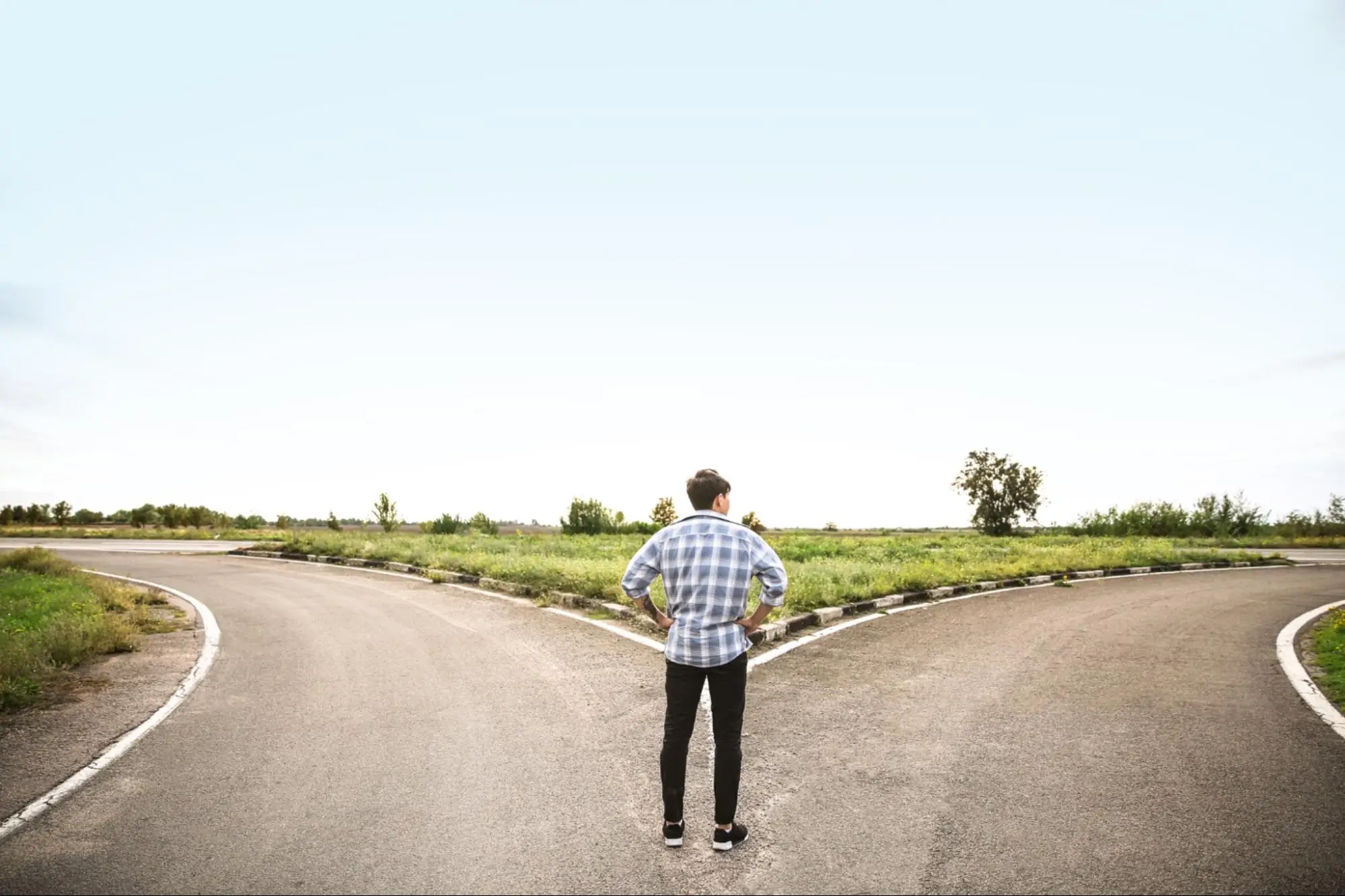 A man standing at a crossroads represents the two choices when it comes to a real estate marketing plan, active or passive.