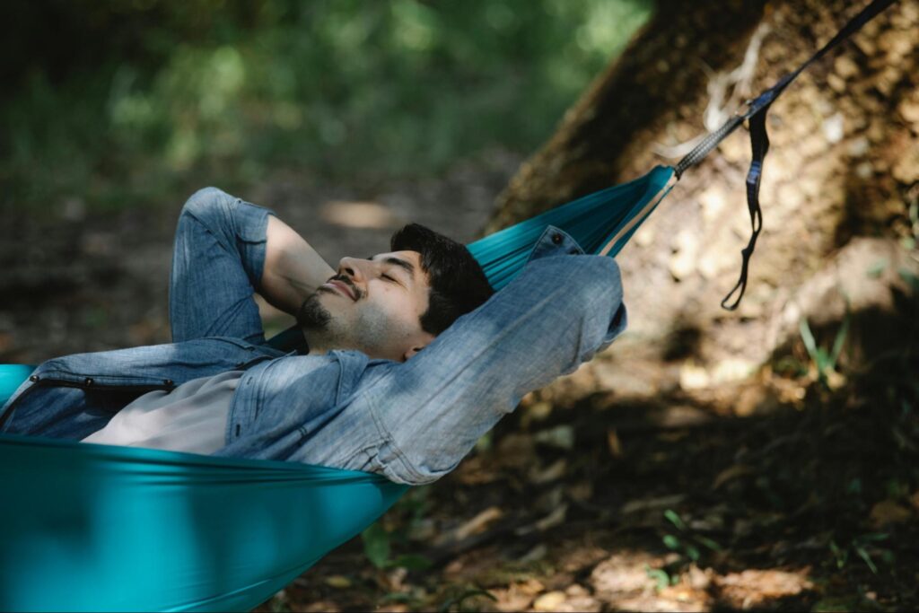Man relaxing in a forest hammock.