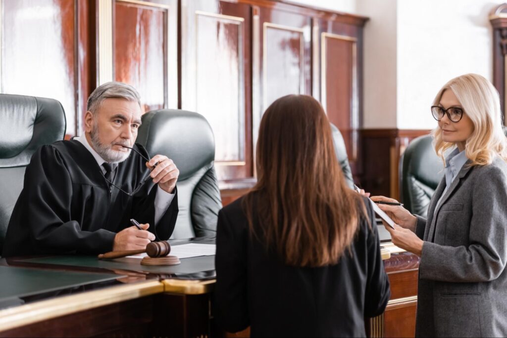 Two people in front of a judge, symbolizing the need to understand legal real estate jargon.