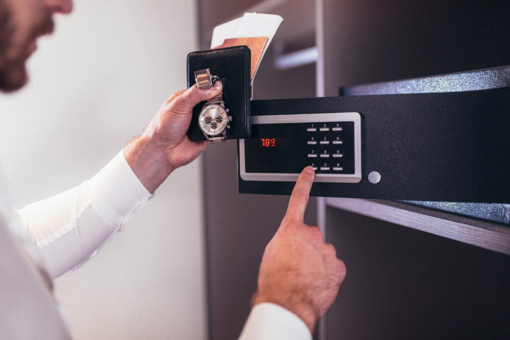 A man placing his expensive watch and wallet into a safe as an example of one of the preparation steps to selling your home.