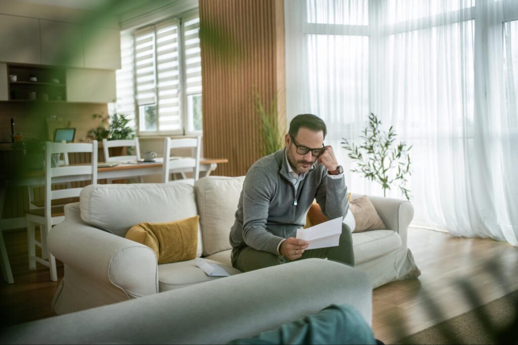 Man standing in a family home, reflecting on memories and saying goodbye.