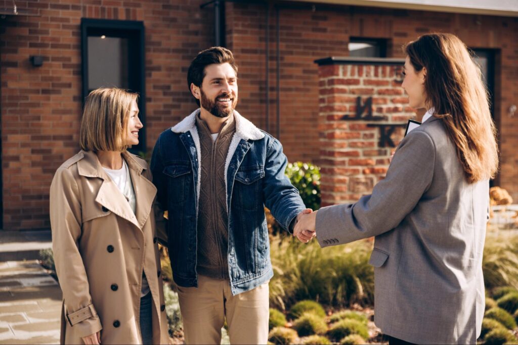 Real estate agent assisting two clients, offering guidance and support.