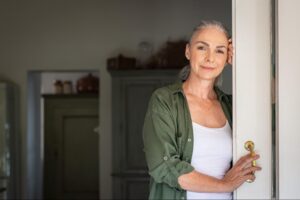“Woman standing in a doorway of a new home, reflecting on a fresh start”
